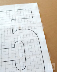 Giant cardboard number template attached to cardboard